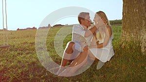 LENSE FLARE: Intimate young couple enjoying their outdoors date on a sunny day