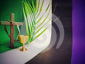 Lent Season and Holy Week Concept - palm leaf,chalice,crown of thorns and wooden cross with multicolored background.