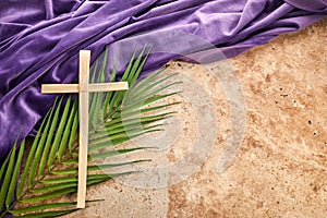 Lent season, Holy week and Good friday concept. Palm leave and cross on stone background