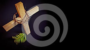 Lent Season,Holy Week and Good Friday concepts - closed up wooden cross,crown of thorns and palm leave in dark background