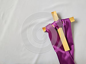 Lent Season,Holy Week and Good Friday concepts - image purple cloth cling to wooden cross background. Stock photo.