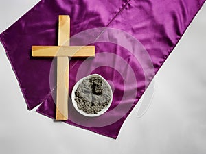 Lent Season,Holy Week and Good Friday concepts - photo of wooden cross and bowl of ash in vintage background. Stock photo.