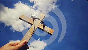 Lent Season,Holy Week and Good Friday concepts - wooden cross raise up to the sky with hand holding it