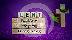 Lent Season,Holy Week and Good Friday concepts - words lent fasting praying almsgiving on wooden blocks in purple vintage