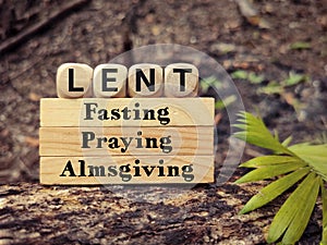 Lent Season,Holy Week and Good Friday concepts - words lent fasting praying almsgiving on wooden blocks background. Stock photo.