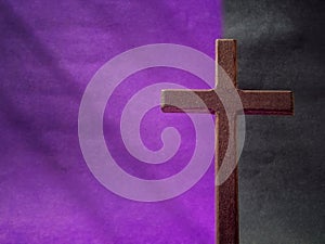 Lent Season, Holy Week, Good Friday, Easter Sunday Concept. Close up of wooden cross in purple black background with copy space.