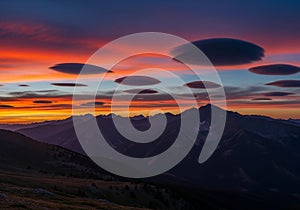 Lenticular clouds hover over a mountain
