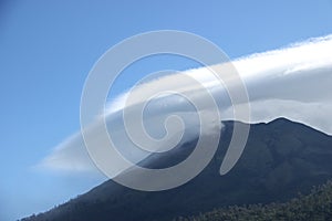 Lenticular clouds are stationary clouds that form in the troposphere in perpendicular alignment to the direction of the wind photo