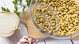 Lentil bowl with water next to onion and garlic