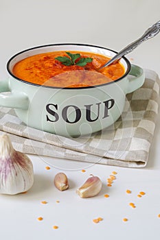 Lentil cream soup in a rustic bowl with garlic.