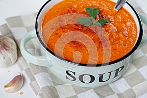 Lentil cream soup in a rustic bowl with garlic.