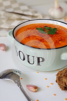 Lentil cream soup in a rustic bowl with piece of black bread