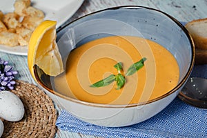 Lentil soup in a blue dish with lemon. Top view