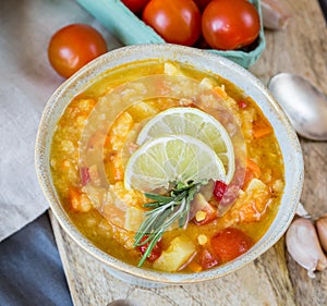 Lentil soup in blue pot with tomatoes