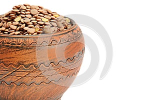 Lentils in a clay pot isolated on white background. Free space for text
