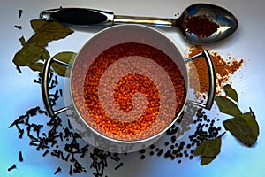 Lentils poured into a pan with turmeric, pepper, bay leaf