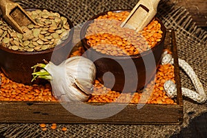 Lentils seeds on a wooden table with sackcloth. Seeds of red and green dietary supplements of lentils. Useful lentils of the legum