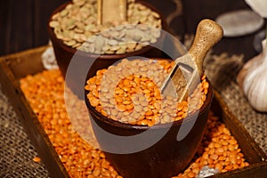 Lentils seeds on a wooden table with sackcloth. Seeds of red and green dietary supplements of lentils. Useful lentils of the legum
