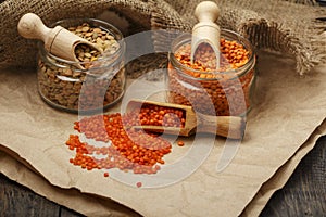 Lentils seeds on a wooden table with sackcloth. Seeds of red and green dietary supplements of lentils. Useful lentils of the legum