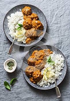 Lentils vegetarian roasted meatballs with curry sauce and rice - healthy lunch on grey background, top view.