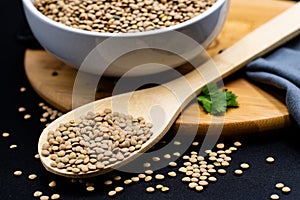 Lentils in wooden spoon with black background