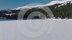 Lenzerheide Heidsee Switzerland with Trees on frozen lake with a small greek