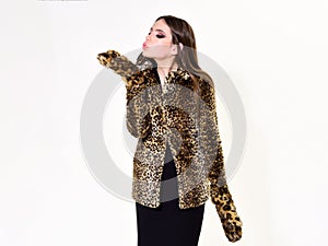 Leopard fur at stylish girl. Look of fashion model with bad taste. Fur coat boutique with natural and artificial