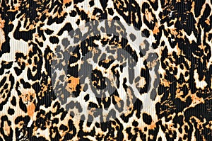 Leopard print (background) on a textured fabric, closeup