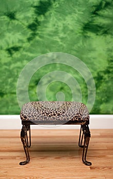 Leopard skin footstool and green background