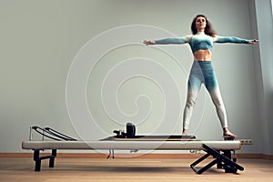 Leotard workout pilates training. athletic pilates reformer exercises. pilates machine equipment. young asian woman