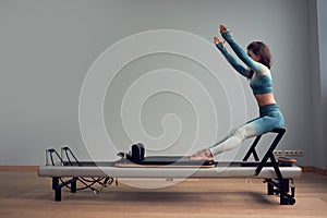 Leotard workout pilates training. athletic pilates reformer exercises. pilates machine equipment. young asian woman