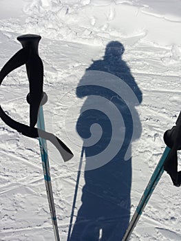 Les Contamines Montjoies, France, February 05 2016 : Shadow of a skier on the slope and ski poles photo