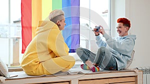 Lesbian Couple Capturing Joyful Moments Together by the Window at Home