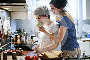 Lesbian couple cooking in the kitchen together