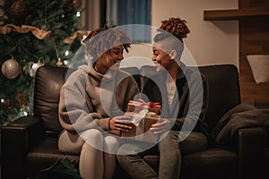 lesbian couple giving gifts and presents to each other, female gay lgbt homosexual african american marriage or black girlfriends