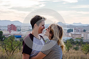 A lesbian couple is hugging in a meadow