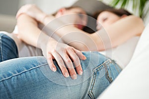 Lesbian couple hugging on sofa