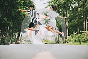 Lesbian couple jumping off the ground outdoor in the park