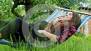 Lesbian couple lie in hammock in garden. Two lesbians girlfriends hug and sleeping