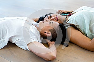 Lesbian couple lying on wooden floor