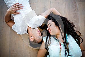 Lesbian couple lying on wooden floor