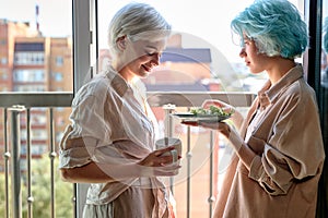 lesbian, couple, romance concept. happy young women have breakfast on balcony