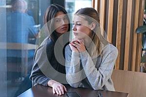 Lesbian couple of women on a date in a cafe. Two gay girlfriends hold hands and flirt in a bistro. Tactile sensations. Lgbt