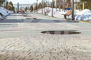 Lesnaya Polyana Residential area, boulevard paved with paving slabs with stella with a clock and a lawn, selective focus