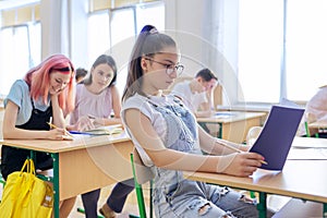 Lesson in class of teenage children, in front girl 13, 14 years old sitting at desk