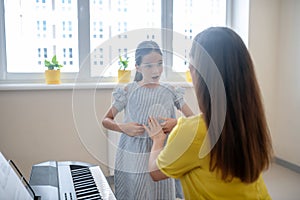 Girl and her music teacher talking and looking involved photo