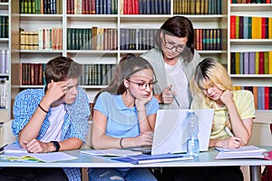 Lesson in library, high school teacher with group of teenagers