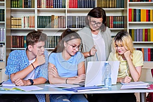 Lesson in library, high school teacher with group of teenagers