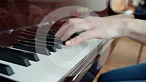 A lesson in a music school, learning to play the piano. Female hands play the piano close-up. A young girl plays