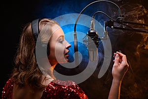 Lesson and training in vocal and singing. A girl sings into a microphone, bright background photo